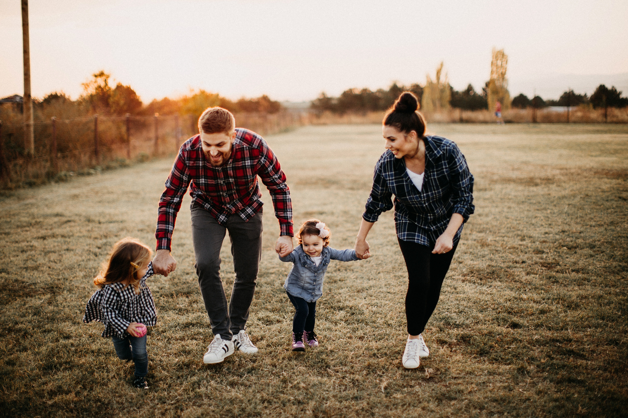 Family walking in a field at sunset