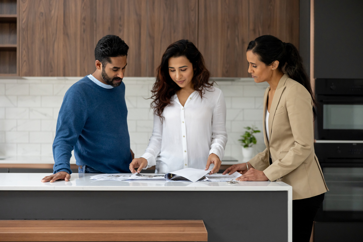 Adviser reviewing mortgage protection papers with homeowners